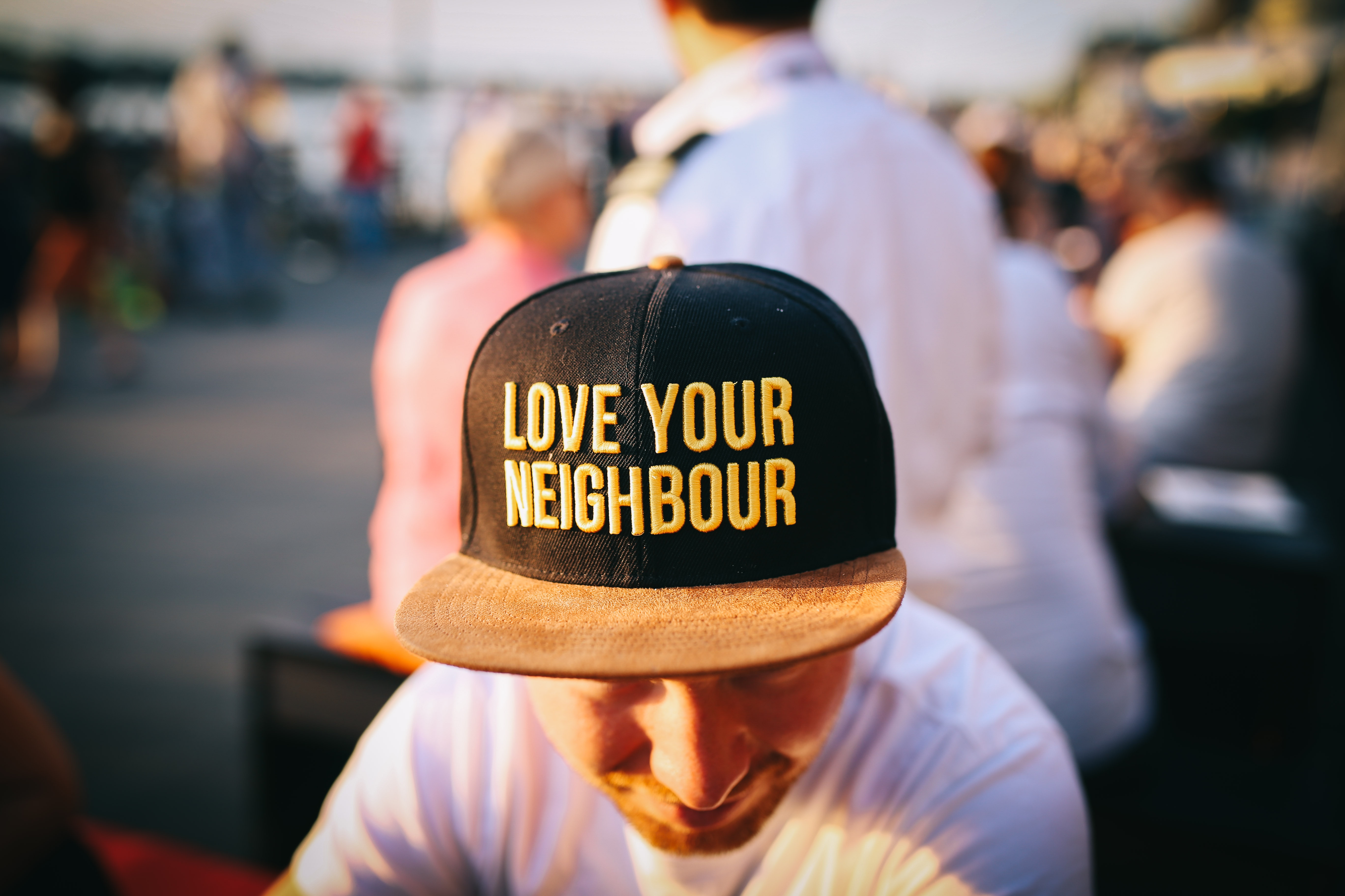 Man wearing a hat that says "Love Your Neighbor"