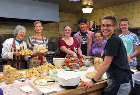 Group of people in the kitchen making pies